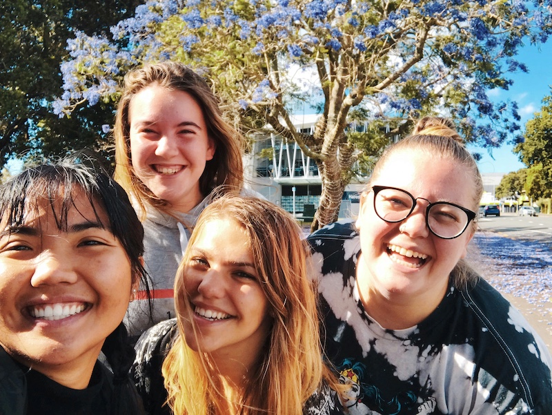 Four girls smiling together outdoors